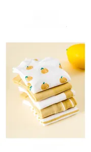 Détail de chaussettes en coton rayées jaune et blanc avec motifs d'agrumes et citron frais