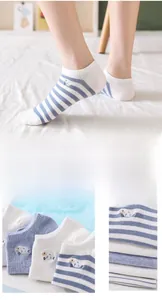 Detail showing blue and white striped socks with cute cartoon sheep embroidery