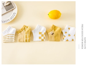 Détails de cinq paires de chaussettes en coton jaune et blanc avec motifs variés