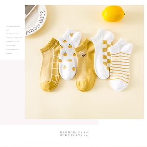 Gros plan de cinq paires de chaussettes en coton jaune aux motifs fleurs et géo