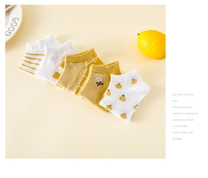 Vue à plat de cinq paires de chaussettes en coton jaune et blanc à motifs floraux marguerites