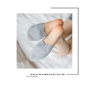 Close-up of light grey mesh no-show socks with breathable fabric on model's feet