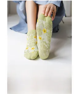 Detailed texture of light green floral knit mesh socks with yellow flower pattern
