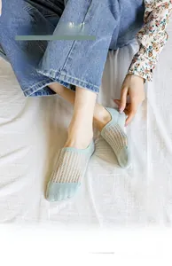 Close-up of light green mesh low-cut socks with breathable geometric knitting texture