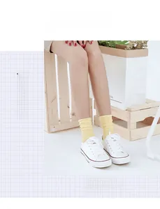 Detail of yellow ribbed cotton socks paired with white canvas shoes in a Japanese style