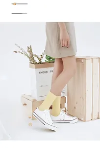 Detail of bright yellow cotton ribbed socks paired with white sneakers in a cozy setting