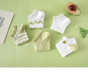 Flat lay of five pairs of avocado green and white low-cut ankle socks with patterns