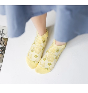 Detail of yellow low-cut mesh socks with small floral embroidery for a fresh summer look
