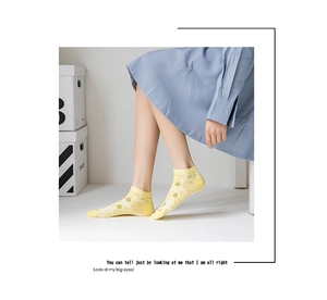 Detailed macro view of yellow floral mesh no-show socks with breathable cotton texture