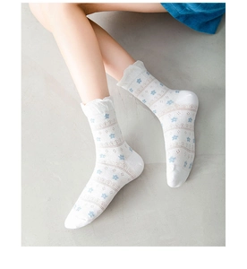 Detail of white cotton mid-calf socks with blue floral pattern and ruffled edges
