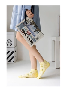 Detail of yellow floral mesh no-show socks with non-slip cuff and cotton texture