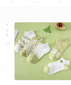 Close-up of five pairs of green and white patterned low cut socks with avocado embroidery