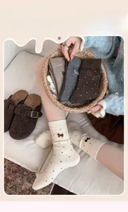 Detail of cashmere socks with cute puppy embroidery and black polka dot pattern