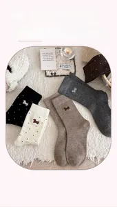 Detail of wool blend socks featuring cute puppy embroidery and polka dot knit patterns
