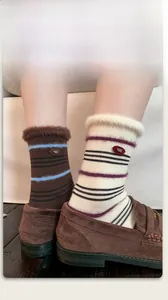 Detail of mink velvet socks with fur trim and stripes worn with brown loafers