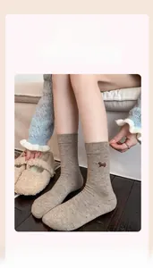 Detail of warm cashmere socks featuring cute dog embroidery and cozy polka dot pattern