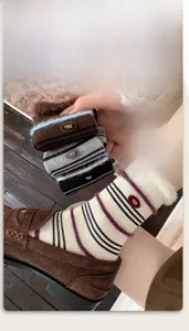 Close-up of cozy striped mink velvet socks featuring plush faux fur trim and egg button detail