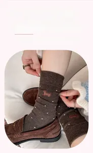Close-up of warm cashmere socks with cute dachshund embroidery and white polka dots