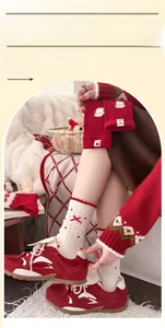 Detail von roten Wollsocken mit süßen Strickmustern und einer zarten kleinen roten Schleife