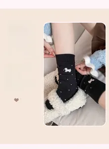 Detail of black cashmere blend sock with white polka dots and puppy embroidery
