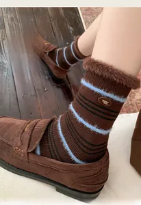 Detail of warm mink fleece socks with blue stripes and brown faux fur trim accents