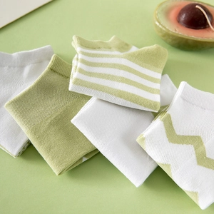 Assorted green and white cotton low-cut socks with fresh avocado-themed flat lay display
