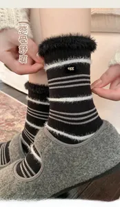 Close-up of black and white striped mink velvet socks with gold egg metal detail