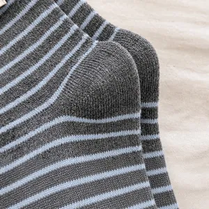 Detailed macro view of the reinforced heel on gray and blue striped wool knit socks