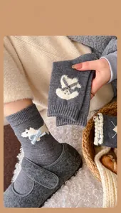 Close-up of wool blend socks with cute dog pattern and 3D bow detail in grey