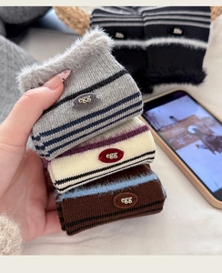 Close-up of winter striped socks with fluffy fur trim and egg decorative leather tag