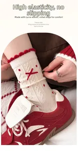 Detail von Wollsocken mit roten Punkten und Schleife, zeigt das rutschfeste Rollbündchen
