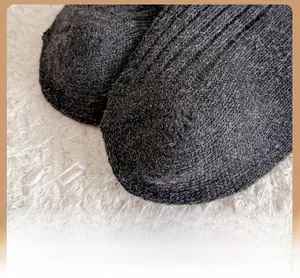 Macro shot of reinforced toe detail on thick wool socks with heavy knit texture
