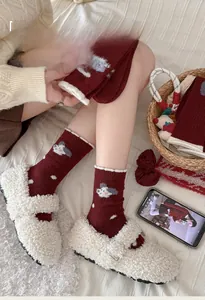 Detailed knit texture of wine red wool socks with white polka dots and cute animal patterns