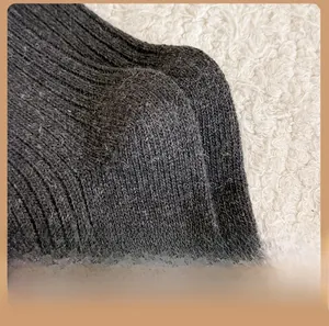 Detailed view of the reinforced heel on a grey ribbed knit wool sock for warmth