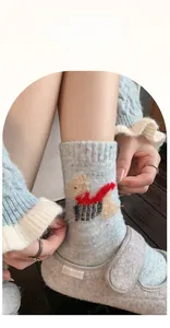 Detail of wool blend socks featuring cute cartoon dog embroidery and colorful flecks