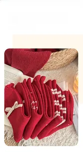 Detailansicht der rot-weißen Strick-Wollsocken mit Schleifen und festlichen Mustern