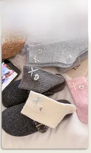 Detail of wool socks featuring decorative silk bows and heart-shaped logo tags