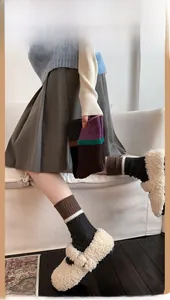 Detail of wool striped socks with color-block knit texture paired with fleece flats