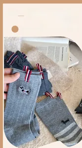 Detail of grey cotton socks with cute dog embroidery and striped pull tab