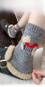 Detail of gray wool blend socks featuring cartoon puppy appliqué and colorful fleck yarn