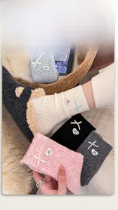 Detail of wool blend socks with cute bow accents and heart tags in cozy winter setting