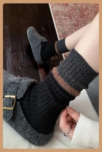 Detail of wool blend socks with brown faux fur trim and gray buckle shoes on vintage rug