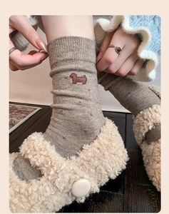 Detail of cashmere blend socks with cute dog embroidery and warm knit texture