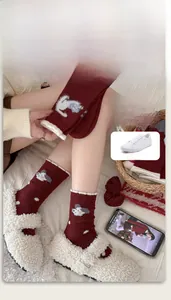 Detail of burgundy wool socks with white fleece trim and cute cartoon dog patterns