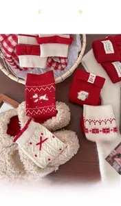 Detail von Winter-Wollsocken mit Comic-Welpenmustern und roten festlichen Schleifen