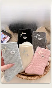 Detail of wool blend thermal socks with sweet ribbon bows and heart buttons in a basket