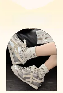 Détail de chaussettes à rayures grises portées avec des baskets réfléchissantes argent