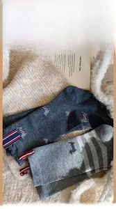 Detail of wool-blend crew socks with dog embroidery and stripe patterns on plush mat