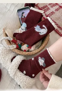 Detailed knit of thick wool socks in burgundy featuring cute cat embroidery and frilly cuffs