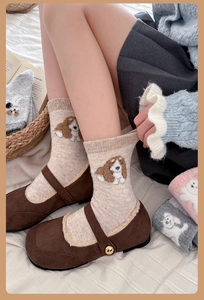 Detailed view of beige wool socks with dog jacquard pattern on a cozy model look